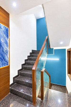 Eine moderne Treppe mit Glastrennwand, Holzhandläufen und einer blauen Akzentwand.