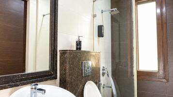 Un baño con un lavamanos grande, inodoro y zona de ducha.
