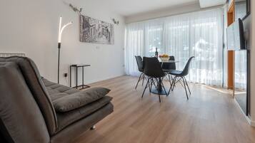Departamento familiar, balcón, vista al mar | Área de sala de estar | Televisión de 98 cm con canales vía satélite