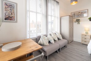 Ein gemütlicher Raum mit einem Holztisch, einer gepolsterten Bank und einem Bett.