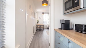 A modern kitchen with a microwave, coffee maker, and wooden countertop. - Host Stay Harbour Lights (Ramsgate)