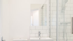 A bathroom with a glass shower enclosure, a white sink, and a toilet. - Host Stay Harbour Lights (Ramsgate)