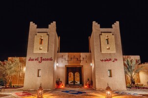 Un edificio tradicional con una entrada central, dos torres y escritura árabe en la fachada.