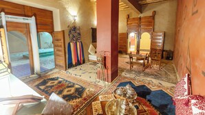 Quarto tradicional com teto de madeira, um tapete grande e um armário de madeira.