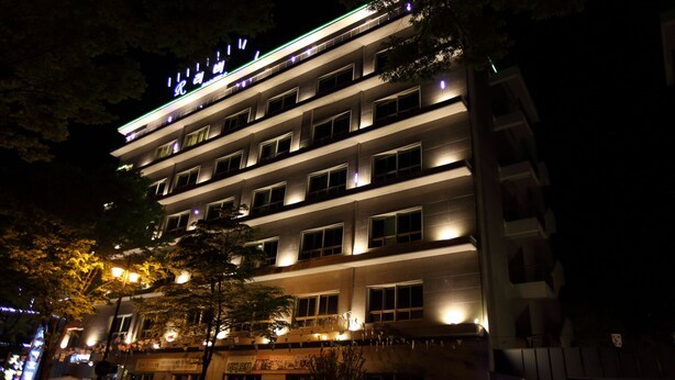 A multi-story hotel with illuminated signage and windows. - RIVER HOTEL NAMWON (Namwon)
