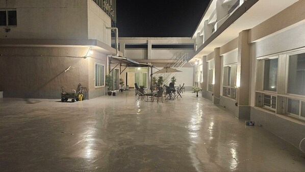A spacious outdoor area with a concrete floor, multiple seating arrangements, and potted plants. - RIVER HOTEL NAMWON (Namwon)