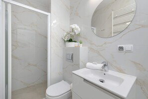 A bathroom with a toilet, sink, and shower.