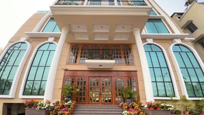 A multi-story hotel with a grand entrance, large windows, and a red carpet leading to the doors. - Hotel Royale de CASA (Guwahati)