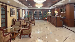 A spacious lobby with a high ceiling, ornate chandeliers, and a reception desk. - Hotel Royale de CASA (Guwahati)