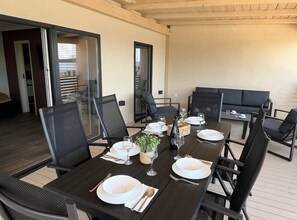 A dining area with a long table set for four, surrounded by black chairs. - Tranquil Tides Drage Mobile Home With Terrace and Sea View (Pakostane)