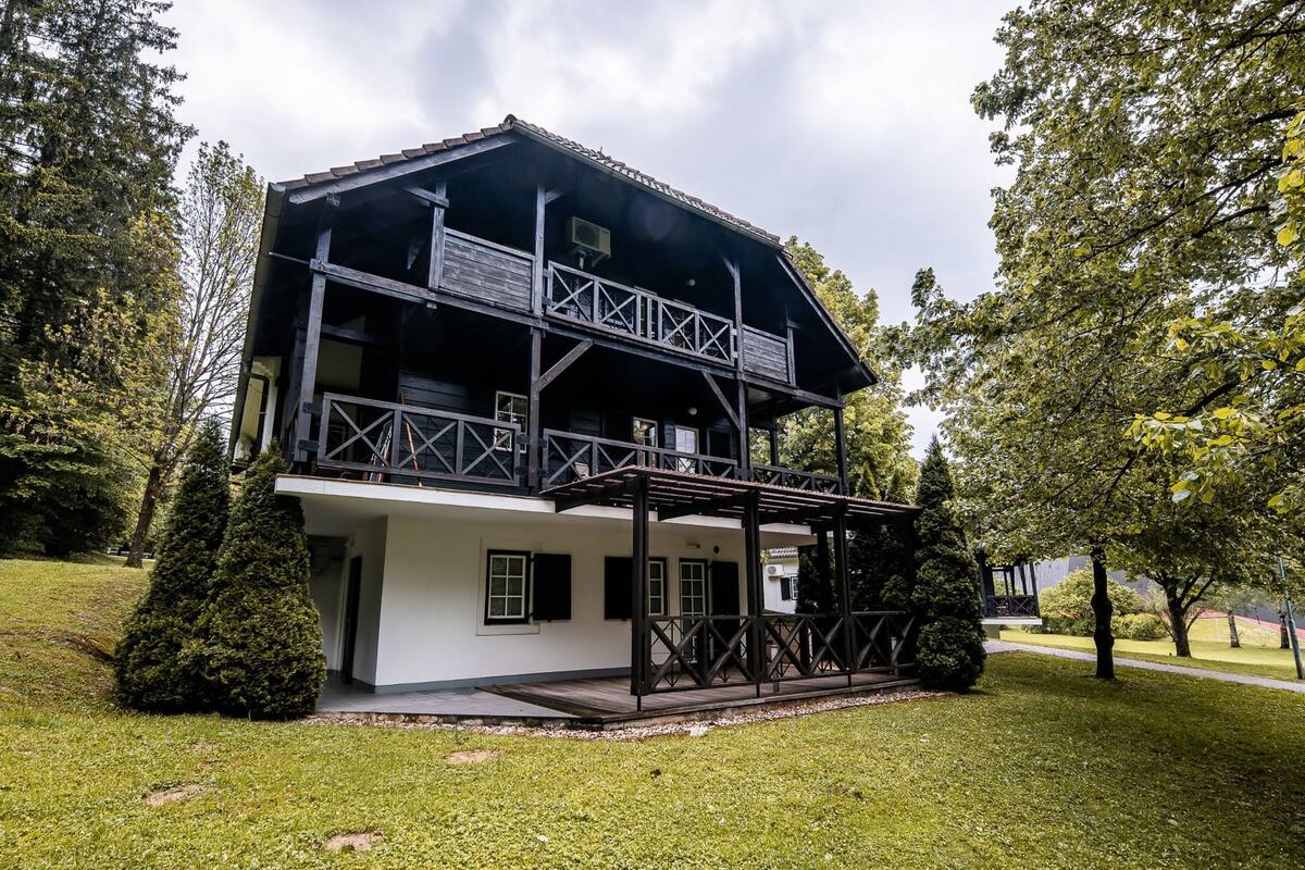 A two-story building with a balcony and a covered porch.