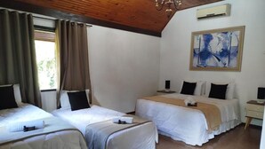 Ein Hotelzimmer mit zwei Betten, einem Bild an der Wand und einer Holzzahl.