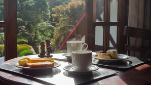 Ein Tisch mit einer Tasse, einem Teller mit Kuchen und einem Teller mit Butter und Toast.