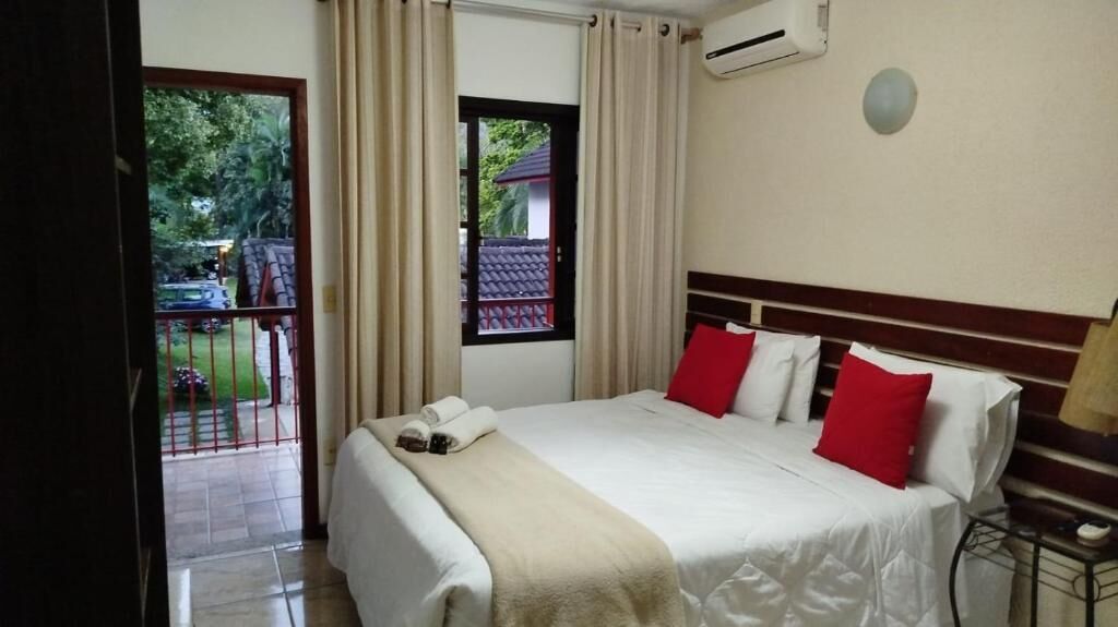 Une chambre d’hôtel avec un lit, une fenêtre, un appareil de climatisation et une vue sur l’extérieur.