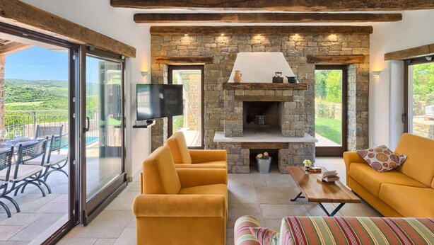 Una sala de estar acogedora con chimenea de piedra, asientos cómodos y un televisor.