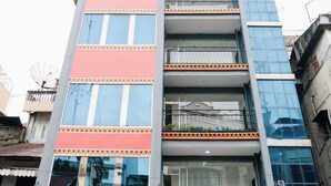 Un edificio a più piani con una facciata moderna, caratterizzato da un rivestimento che combina vetro e pannelli solidi, e un tetto piatto.