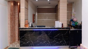 Una cucina moderna con un piano di lavoro in marmo, rivestimenti in legno e forno integrato.
