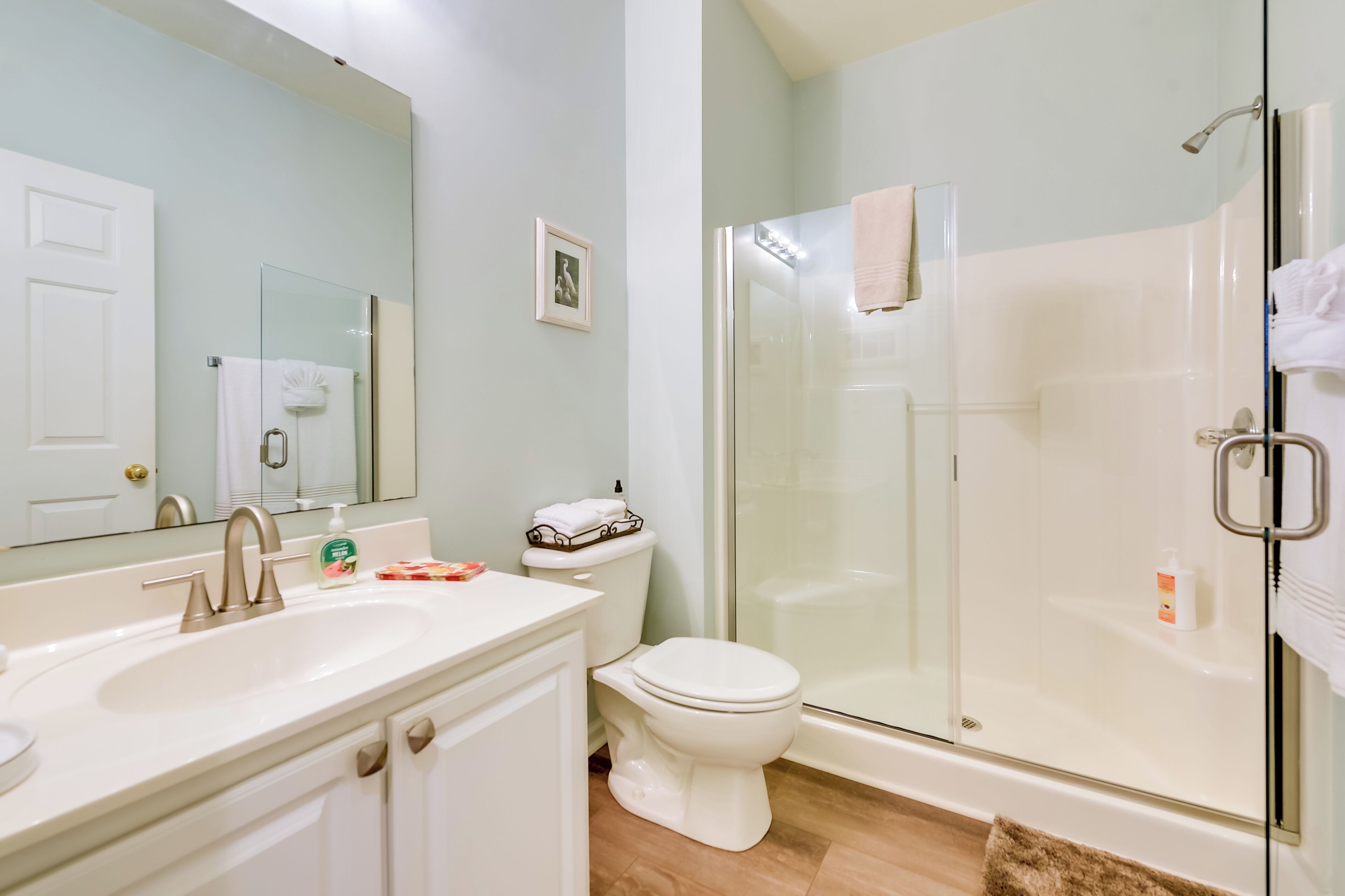 A modern bathroom with a glass-enclosed shower, a white sink, and a toilet.