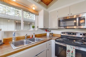 A modern kitchen with a stainless steel stove, double sink, and wooden countertops.