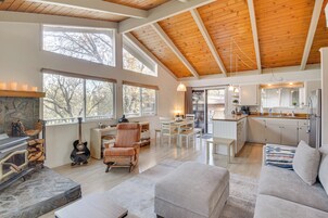 A spacious living area with a fireplace, a dining table, and a kitchen in the background.