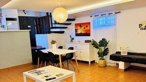 Un espace de vie compact comprenant un coin repas, une cuisine et un escalier menant à un niveau supérieur.