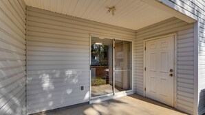 A house with a sliding glass door leading to a covered patio area. - 3 Mi to Fsu: Townhome w/ Patio in Tallahassee! (Tallahassee)