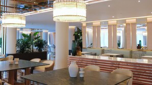A modern hotel lobby with a glass-top table, white chairs, and a large mirror. - ZEM Wellness Clinic Altea - 5 Stars Grand Luxury (Altea)