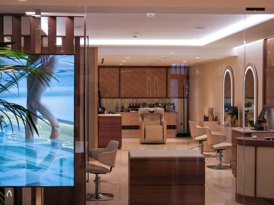 Un interior moderno con un separador de vidrio, una zona de recepción y un bar.