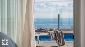 A balcony with a view of the sea, a pool, and a bed with a blanket and a cup. - Villa YANSA by Abahana Villas (Benitachell)
