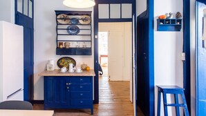 A kitchen with blue cabinets, a wooden countertop, and a hanging light fixture.