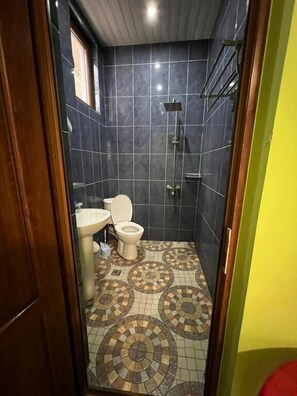 A small bathroom with a toilet, sink, and shower. - MARETI HOTEL (Batumi)