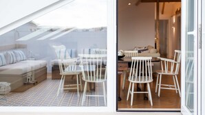 Um interior moderno com área de jantar, sofá e piso estampado.