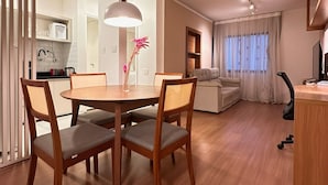 Ein modernes Wohnzimmer mit Essbereich, einer Couch und einem Fernseher.