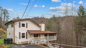 A two-story house with a porch, a staircase, and a fenced yard. - New Listing! Hot Tub, Foosball, Fireplace, Pool Table, & Free Attractions! (Sevierville)