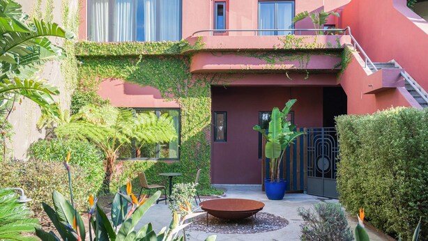 A courtyard with a circular seating area, potted plants, and a staircase leading to an upper level. - Liiiving in Porto - Casa Duque Apartment I (Porto)