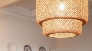 A kitchen with a hanging light fixture, a wooden table, and chairs. - Liiiving in A Ores - Ocean View House (Sao Roque do Pico)
