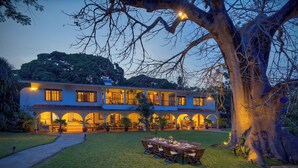 A two-story building with a covered patio and outdoor seating area. - Lazy Days (Diani Beach)