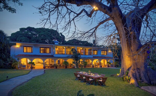 A two-story building with a covered patio and outdoor seating area. - Lazy Days (Diani Beach)