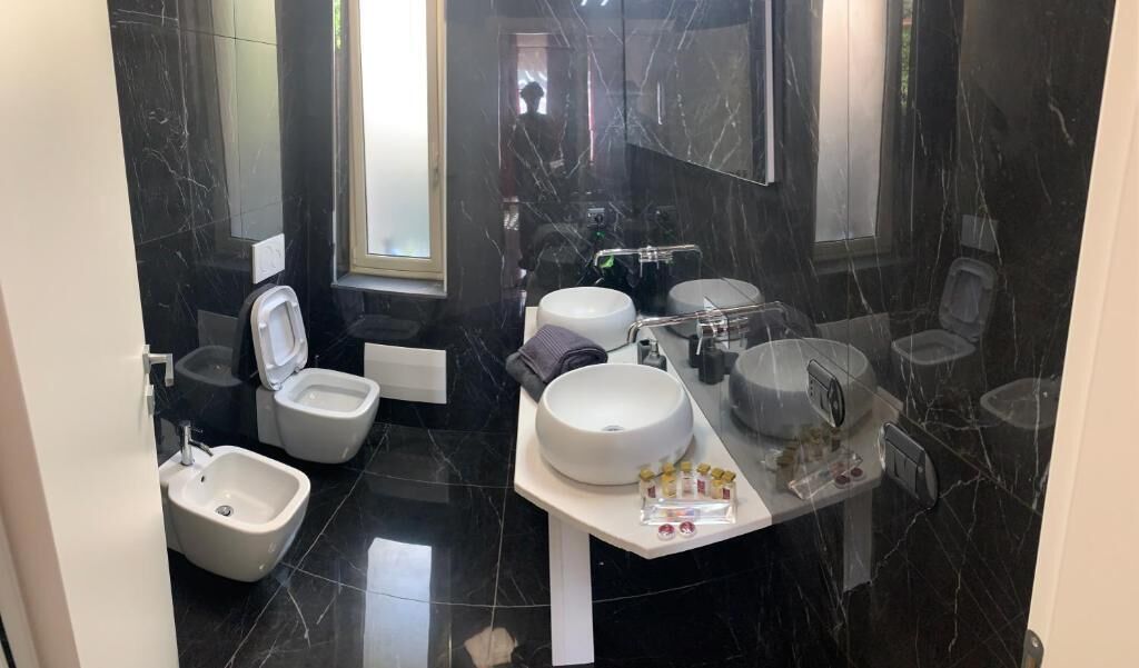 Une salle de bain moderne équipée d’un bidet, de toilettes et de deux lavabos.