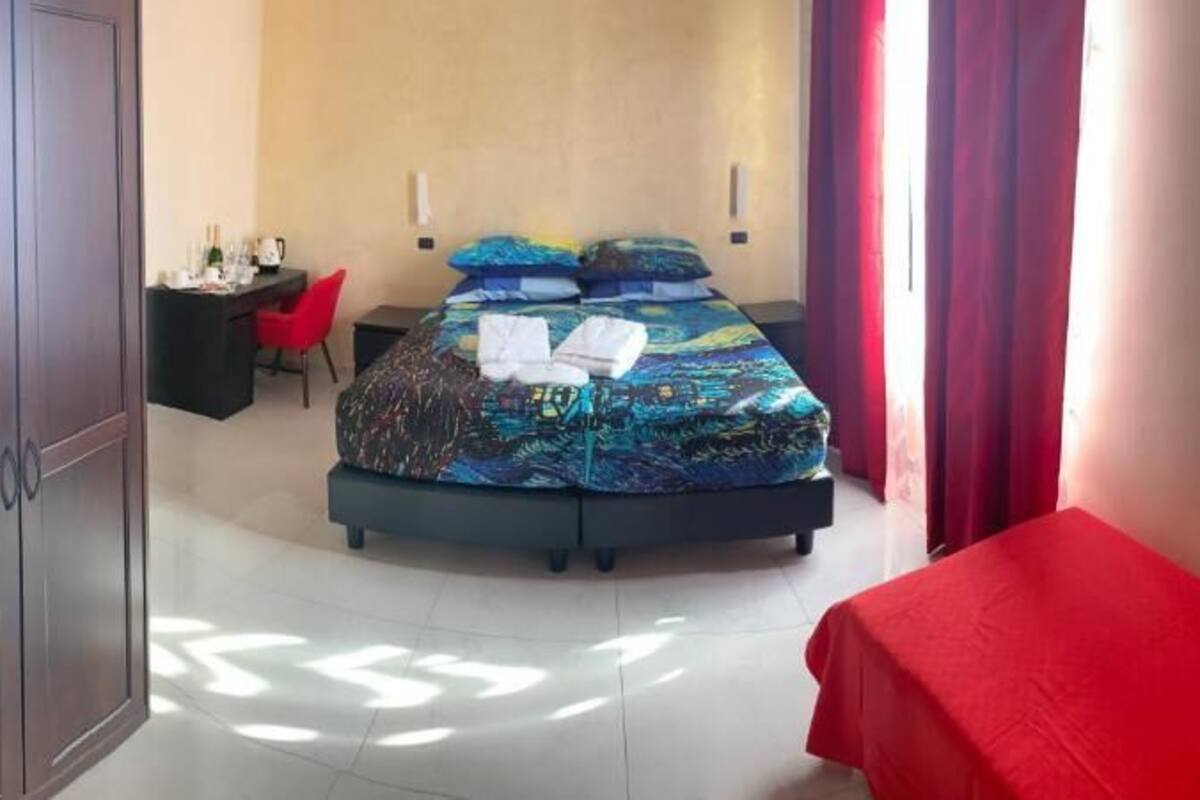 A hotel room with a bed, a desk, and a chair.