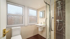Ein Badezimmer mit Toilette, Waschbecken, Spiegel und Dusche mit einer Wand im Zebra-Muster.