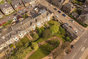 An aerial view of a residential area with houses, roads, and greenery.