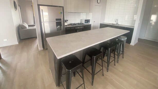 A modern kitchen with a central island, stainless steel appliances, and a tiled backsplash. - Lofty's Shack - Modern 3 bedroom, Free WiFi!, Off peak special! (Edithburgh)