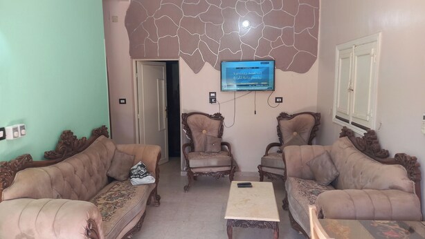 A living room with two sofas, a coffee table, and a television mounted on the wall.