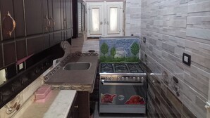 A compact kitchen with dark cabinets, a gas stove, and a sink.