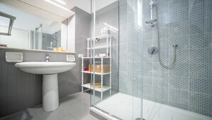 A modern bathroom with a glass shower enclosure, a pedestal sink, and a built-in shelf unit. - Solemar Sicilia - Casa Carina (Bagheria)
