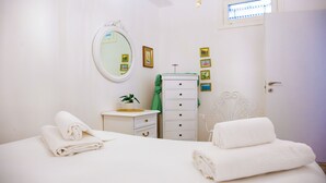 A bedroom with a bed, a dresser, a mirror, and a door. - Solemar Sicilia - Casa Carina (Bagheria)