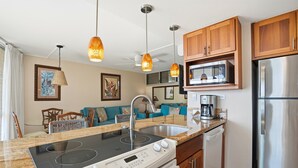 A modern kitchen with a built-in oven, microwave, and stainless steel refrigerator. - Kamaole Nalu, #304 2 Bedroom Condo (Kihei)