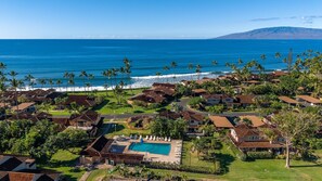 Una zona residencial costera con casas, una piscina y vistas al océano.