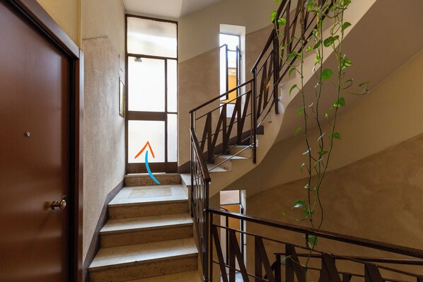 A staircase with a handrail, a door, and a window with a view of the outside.